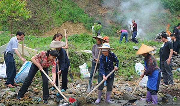 自治县党委副书记胡革（前左一）在所略乡参与清洁活动。